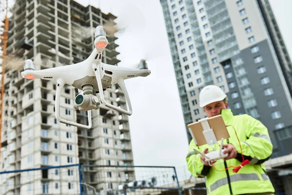 A pilot flying a survey drone on a construction site